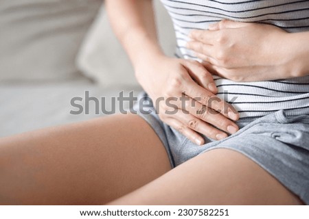 Woman having a stomachache, or menstruation pain. suffering from abdominal. Menstrual cramps. Healthcare and medical, gynecology concept.  Royalty-Free Stock Photo #2307582251