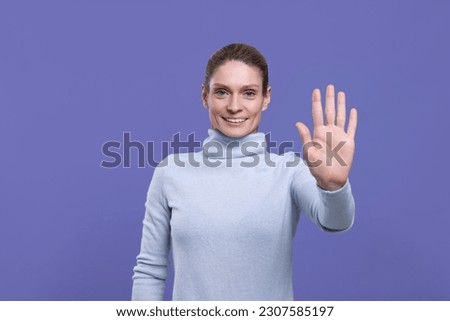 Woman giving high five on purple background