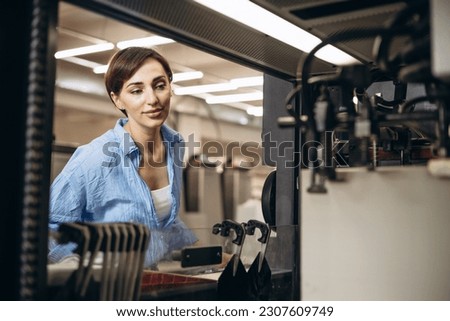 Woman working in printing house with paper and paints
