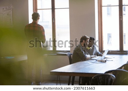 Creative business people working at laptop in office