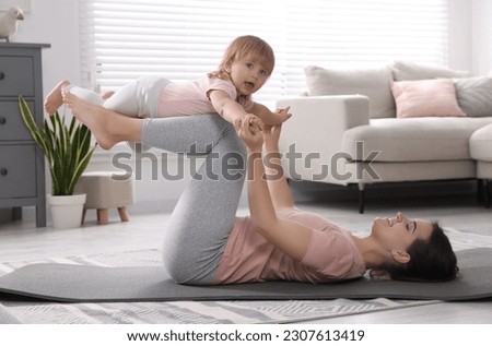 Mother doing exercise with her daughter at home