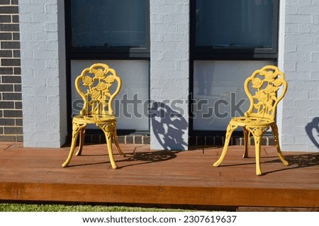 Gold chairs on the front landing of a house in the suburbs