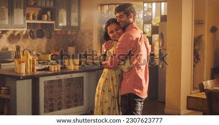 A Heartwarming Moment of Reunion: Young Couple Meet at Home and Greet Each Other with Warmth and Affection after Long Parting. Embracing Each Other Lovingly, Emotional Connection. Royalty-Free Stock Photo #2307623777