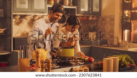 Loving Indian Couple Preparing Food Together in the Kitchen: Young Lovely Couple Enjoy Spending Time together, Learning New things, Creating Delicious Experiences. Preparing Dinner For Family, Friends Royalty-Free Stock Photo #2307623841