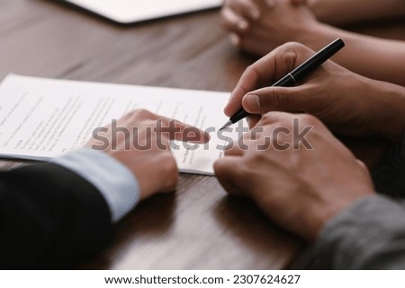 Notary helping couple with paperwork at wooden table, closeup Royalty-Free Stock Photo #2307624627