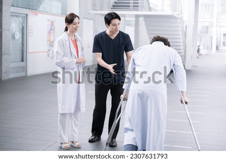 Medical image of a nurse (physiotherapist), doctor and patient working in a large ward, such as a university hospital Full body, wide angle cut