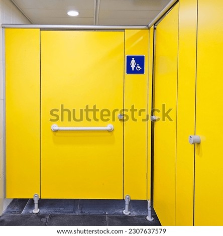 Yellow closed doors with sign of woman and disable people in a public toilet
