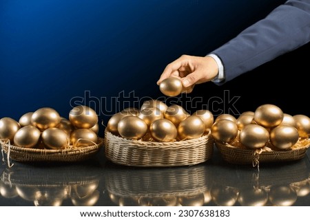 smart business man hand allocates golden egg into many baskets. do not put all eggs in one basket. has a very good return on investment in each business Royalty-Free Stock Photo #2307638183
