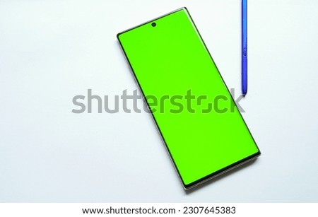 real mockup of a smartphone with stylus pen and a green screen, for advertising needs on social media isolated white background