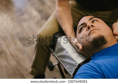Latino patient gets neck adjustment from chiropractor Royalty-Free Stock Photo #2307648381