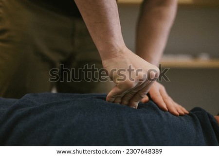 Close up of Chiropractors hands giving adjustment along spine Royalty-Free Stock Photo #2307648389