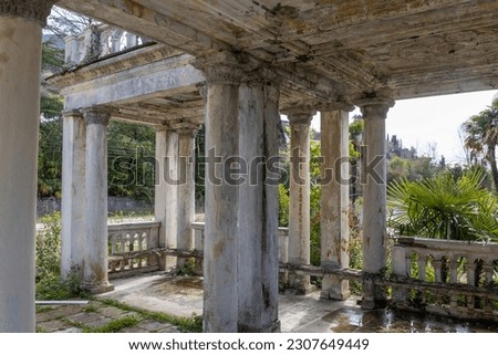 Fragment of decay marble colonnade of abandoned railway platform Gagrypsh overgrown with tropical greenery in Gagra, Abkhazia, Georgia Royalty-Free Stock Photo #2307649449