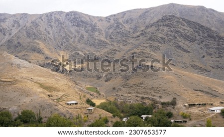 Small houses in the background of a mountain landscape                             