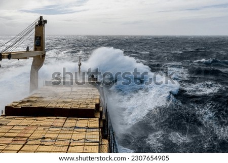 Cargo vessel with deck cargo at stormy sea. View from navigational bridge. Stormy sea, Bad weather. Gale. Rough sea. Royalty-Free Stock Photo #2307654905