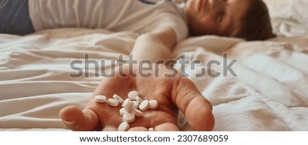 Child lies on bed with overdose of pills. Drug poisoning in children Royalty-Free Stock Photo #2307689059
