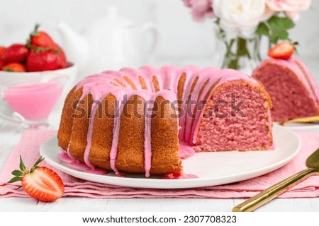 Strawberry bundt cake with pink icing on a plate. Summer berry pastry. Selective focus