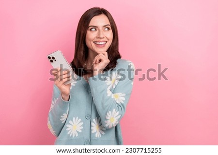 Photo of dreamy sweet woman dressed teal outfit looking empty space communicating modern gadget isolated pink color background