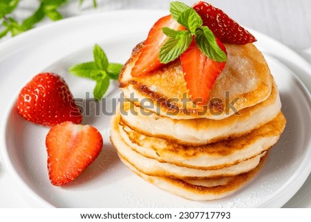 Yummy and fresh mini pancakes with strawberry for summer breakfast