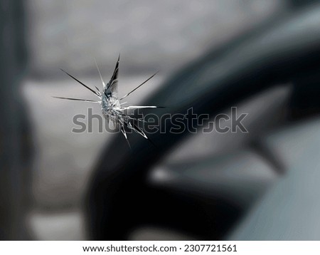close up of a stone chip in the windshield of a car, detail shot of cracks in car glass on the drivers side Royalty-Free Stock Photo #2307721561