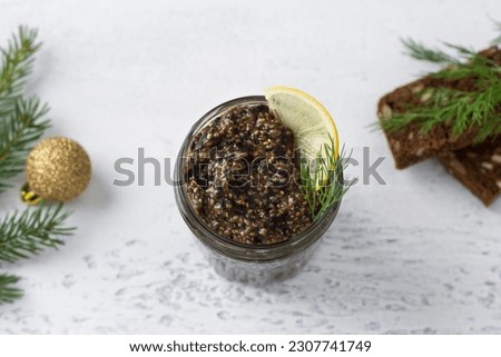 Vegan healthy chia caviar with nori and soy sauce in a jar, bread with seeds and greens on light blue background with christmas decorations, top view
