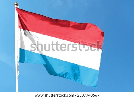 Luxembourg flag in the cloudy sky. waving in the sky