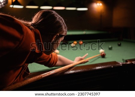 Female ball play snooker billiard player with cue aiming at the table. Billiards sport concept. Close-up Royalty-Free Stock Photo #2307745397