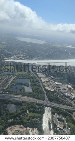 view from airplane of London with the aircraft wing in frame 