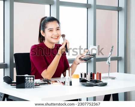 Asian pretty blogger girl share trick use eye shadow palette color and blush on her face skin and makeup collection set including lipstick, eyeliner, powder and mirror on the white table