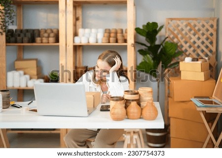 Caucasian entrepreneur girl tired and stress about business problem and lose the money of the first product lot cannot sell when she check online order in the computer at home office