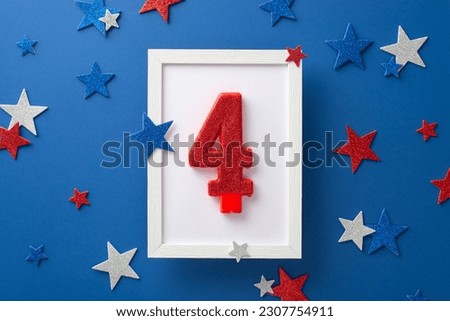 Top view shot capturing the celebratory atmosphere of Independence Day: shiny stars, and photo frame with number 4 candle, positioned on a blue backdrop