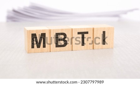 mbti text written on wood blocks, stack of white sheets in the background