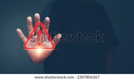 Human hand showing red triangle caution warning sign for maintenance notification error and risk concept. Royalty-Free Stock Photo #2307806367