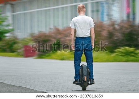 Man riding on monowheel. Man commuting to work, riding electric unicycle (EUC). Man driving electric mono wheel, ecological transportation in city.
 Royalty-Free Stock Photo #2307813659