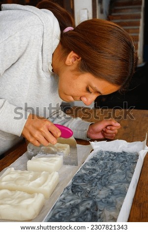 Teenage girl cutting natural cold process organic soap at home Royalty-Free Stock Photo #2307821343