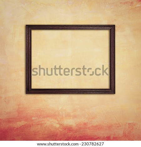 Wooden photo frame on old yellow concrete wall