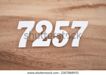 White number 7257 on a brown and light brown wooden background.