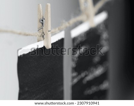 Close-up of photo frames hanging on the rope with wooden pins.