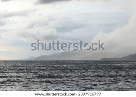 storm over the sea with mountains in the background