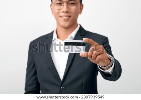 Photo of stylish handsome young man holding credit card isolated on white background