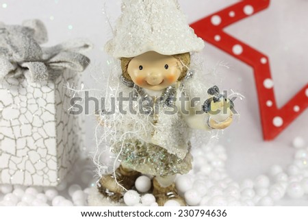Cute elf girl smiling and holding a little bird in her hand.Wonderful winter scene, on brilliant white  background.It's Christmas time,magical atmosphere