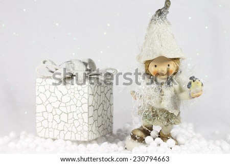 Cute elf girl smiling and holding a little bird in her hand.Wonderful winter scene, on brilliant white  background.It's Christmas time,magical atmosphere