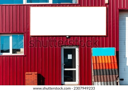 Construction store building wall with white poster mockup.entrance door to the shop.