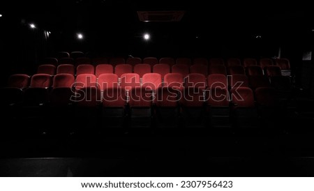 stage light hitting red cloth seats in theater , movie theater, cinema seats Royalty-Free Stock Photo #2307956423