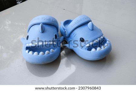cute children's slippers with a blue shark character 