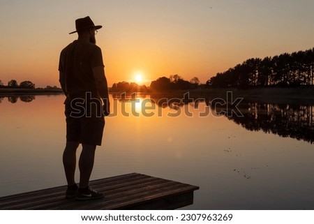 Landscape photography of summer sunset on Venta river with a man in hat silhouette 