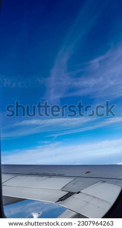 Clear blue sky with fluffy ornamental cumulus clouds, panoramic view from an airplane, wing close-up. Dreamlike cloudscape. Travel, tourism, vacations, weekend, freedom, peace, hope, heaven concepts. 