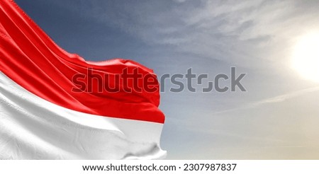 Indonesia national flag cloth fabric waving on beautiful grey sky Background.