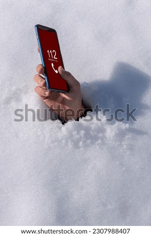 Young man buried in snow, tries to call emergency services Royalty-Free Stock Photo #2307988407
