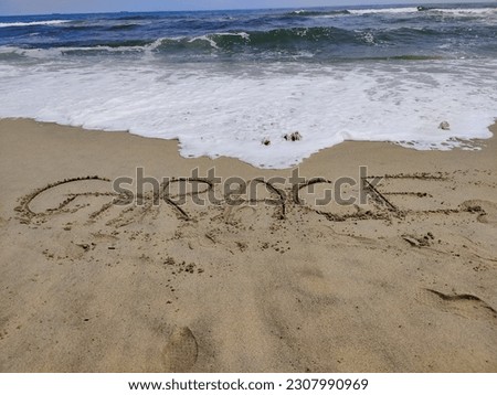 The word Grace is written on the Sandy Hook beach and the waves on the shore