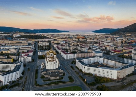 Aerial view of the city of Magadan. Beautiful morning cityscape. Top view of the Cathedral, streets and buildings. In the distance, mountains and a sea Bay. Magadan, Magadan Region, Russian Far East. Royalty-Free Stock Photo #2307995933